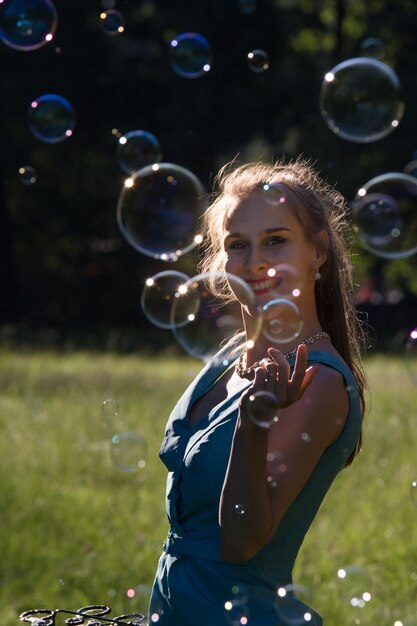 Foto ein mädchen macht im park große seifenblasen