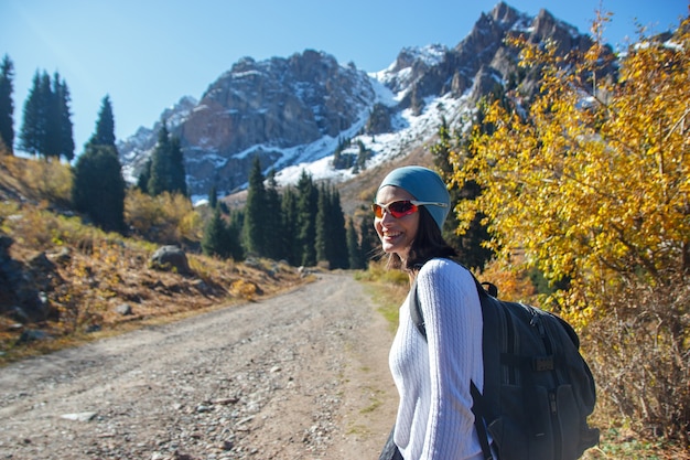 Ein Mädchen mit Brille geht in die Berge. Die Straße in den Bergen.