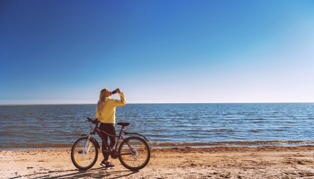 Ein Mädchen mit dem Fahrrad am Meer