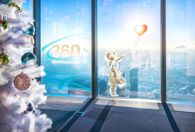 Ein Mädchen mit einem Ballon auf dem Glas und der Aufschrift 360 we are about the present auf dem Fenster Federation Tower Moscow City Moscow
