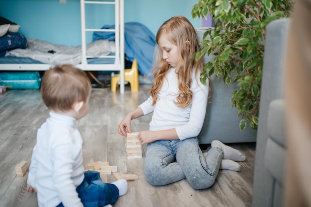 Foto ein mädchen mit einem kleinen bruder, das auf dem boden django spielt