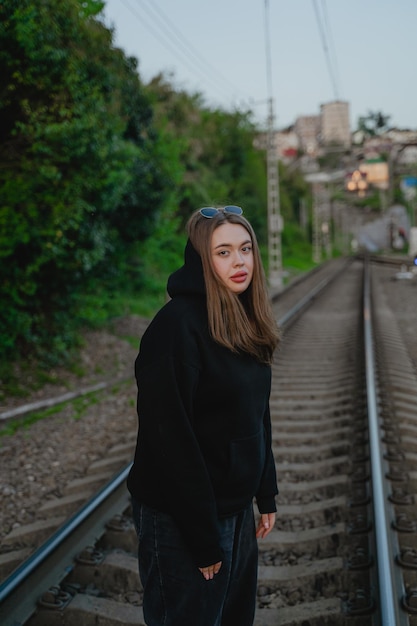 Ein Mädchen mit müdem Blick steht auf der Eisenbahn