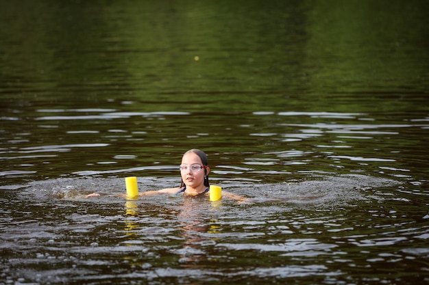 Ein Mädchen schwimmt an einem heißen Sommertag im Fluss