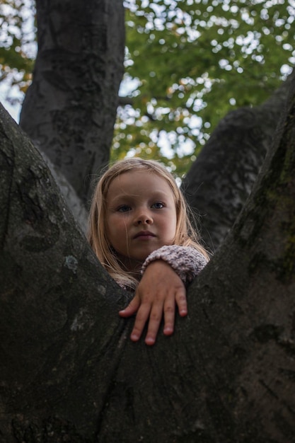 Ein Mädchen spielt auf einem Baum im Park