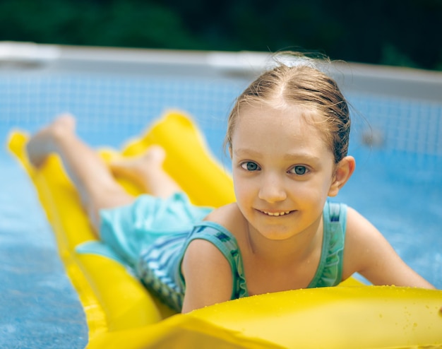 Ein Mädchen spielt im Pool.