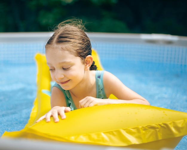 Ein Mädchen spielt im Pool.