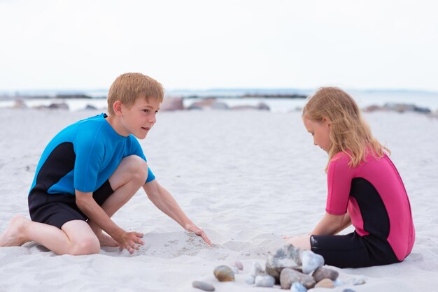 Foto ein mädchen spielt mit seinem bruder am strand