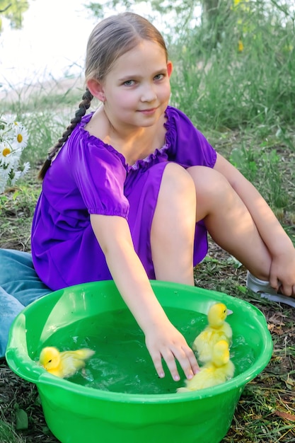 Ein Mädchen und ein Entlein im Sommer im Freien Gute Babys Happiness