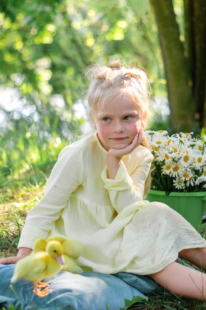 Ein Mädchen und ein Entlein im Sommer im Freien Gute Babys Happiness