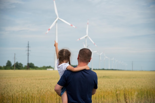 Ein Mädchen und ihr Vater schauen sich den Windgenerator im Feld Ecology Future an