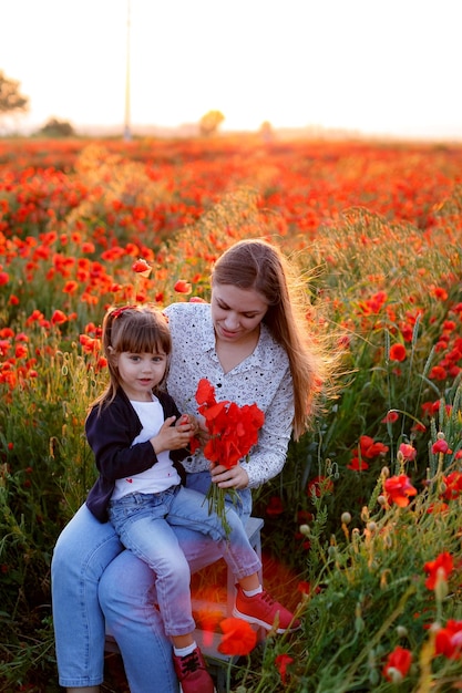 Ein Mädchen und ihre Mutter amüsieren sich auf einem Mohnfeld