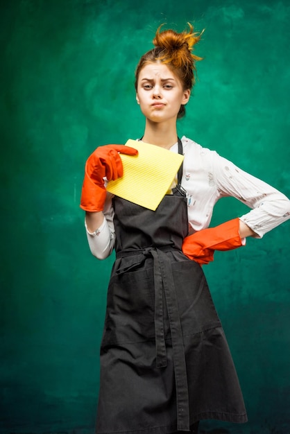 Ein Mädchen wird putzen, ein Putzanzug, orangefarbene Handschuhe, eine Schürze