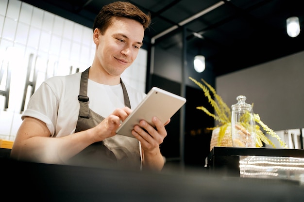 Ein männlicher Angestellter hat sein eigenes kleines Café. Ein Startup-Unternehmer