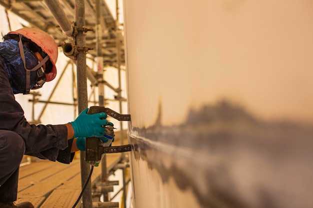 Ein männlicher Arbeiter an einer Stumpfschweißnaht aus Stahltank mit hoher Prüfung überlagert eine Kohlenstoffschalenplatte aus Lagertanköl