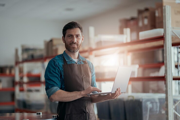 Foto ein männlicher arbeiter arbeitet mit einem laptop im hintergrund eines lagerhauses