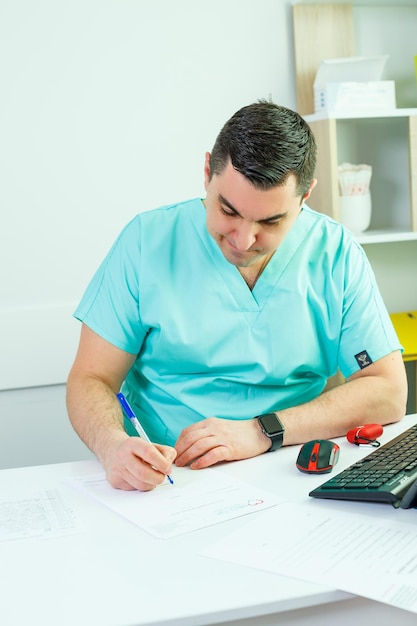 Ein männlicher Arzt arbeitet in einem Krankenhaus. Sitzt am Tisch und prüft die Analysen des Patienten.