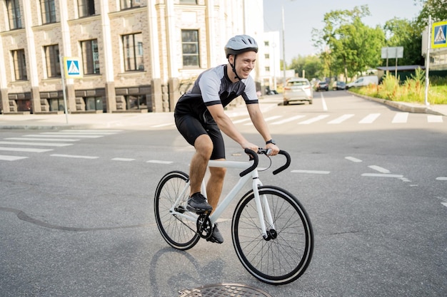 Ein männlicher Athlet in Ausrüstung fährt ein Fahrrad-Cardio-Training in der Stadt des Ökotransports