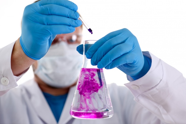 Ein männlicher Chemiker hält Reagenzglas aus Glas