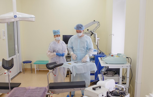 Ein männlicher Chirurg legt zusammen mit einem Assistenten sterile Instrumente zur Vorbereitung der Operation bereit