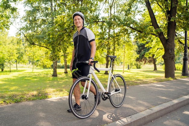 Ein männlicher Radfahrer mit Helm fährt mit einem Fahrrad-Öko-Transport in der Stadt