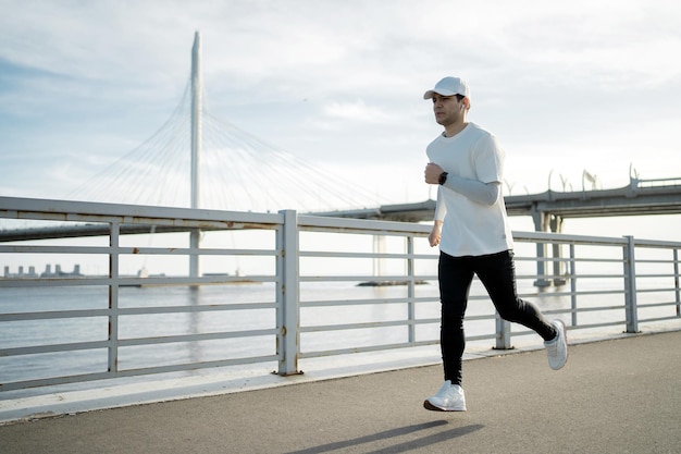 Ein männlicher Sportler verwendet eine Fitnessuhr an seinem Arm Outdoor-Training