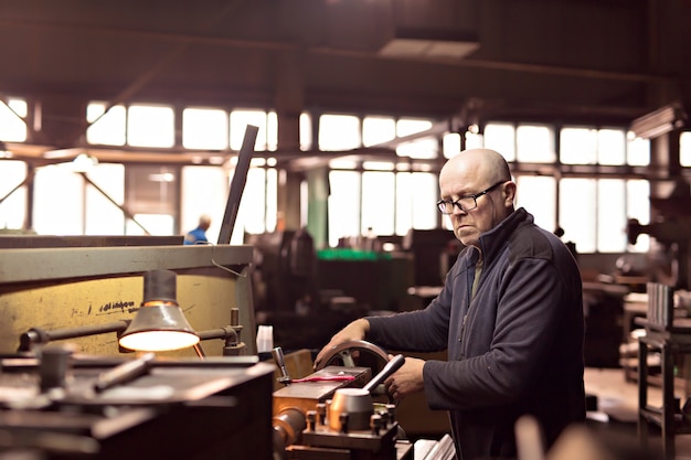 Ein Mann arbeitet an der Maschine in der Fabrik