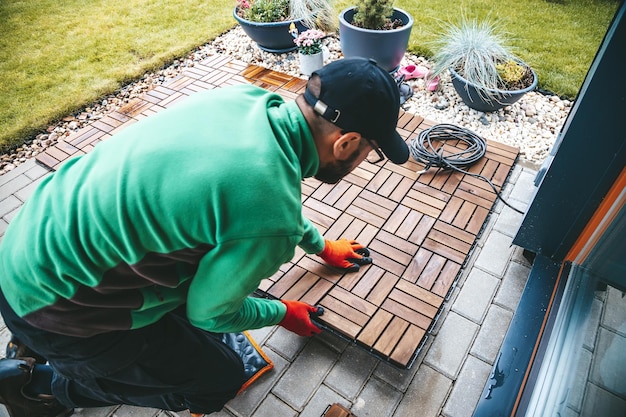 Ein Mann arbeitet hart daran, Holzböden auf der Terrasse zu verlegen