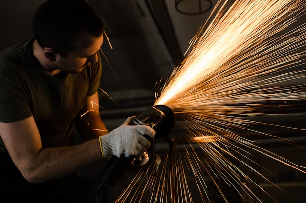 Ein Mann arbeitet mit Metall und Funken fliegen wunderschön