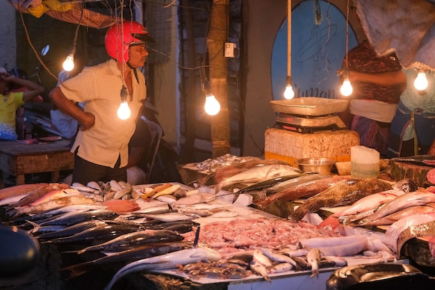 Ein Mann auf dem Fischmarkt in der Stadt viel frisches Meeresprodukt auf der Theke des Straßenmarktes in