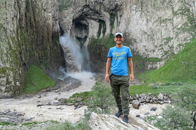 Ein Mann auf dem Hintergrund des Wasserfalls KarakayaSu auf dem Territorium von KabardinoBalkarien