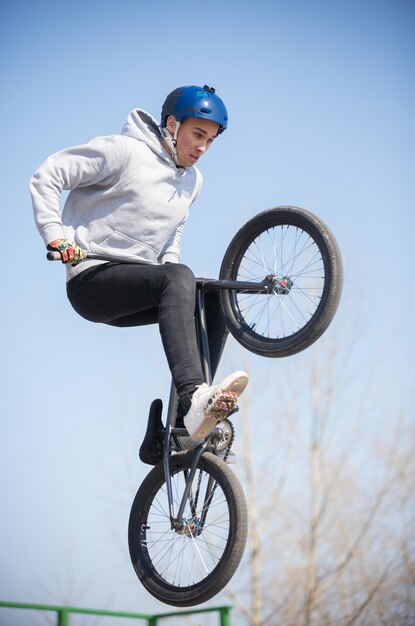 Ein Mann auf einem Fahrrad balanciert auf dem Hinterrad