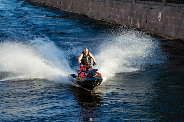 Ein Mann auf einem Jetski fährt auf dem Wasser.