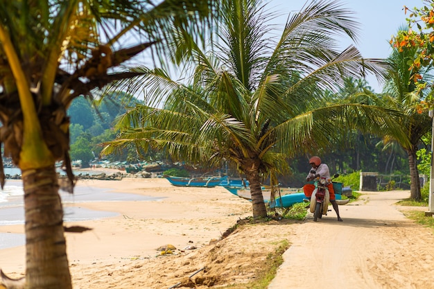 Ein Mann auf einem Moped kam am Strand zur Ruhe. Colombo, Sri Lanka - 02.10.2018