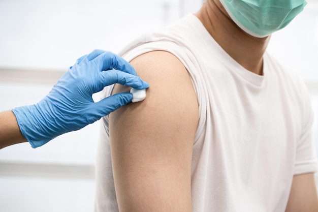 Ein Mann bekommt im Krankenhaus einen Covid-19-Impfstoff. (Fokus auswählen)