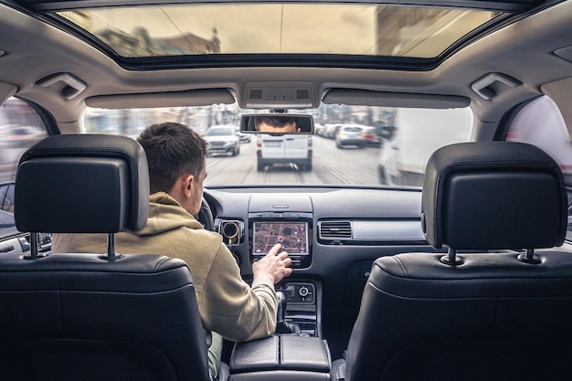 Ein Mann berührt den Bildschirm eines GPS-Navigationssystems in seinem Auto