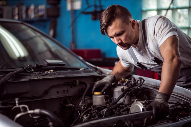 Ein Mann, der an einem Automotor arbeitet, auf dem das Wort „Auto“ steht