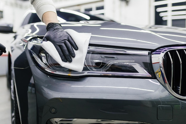 Ein Mann, der Auto mit Mikrofasertuch reinigt, Konzept der Autopflege (oder Valeting). Selektiver Fokus.