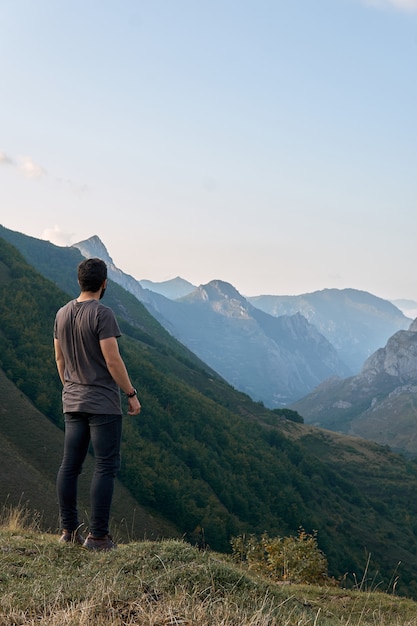 Ein Mann, der die entfernten Berge betrachtend steht