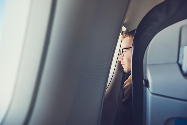 Foto ein mann, der durch das flugzeugfenster schaut