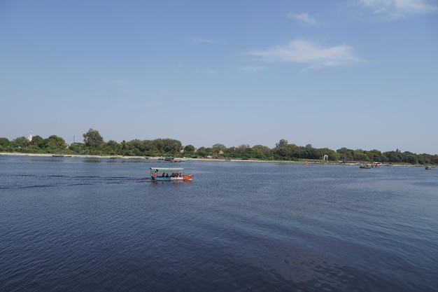 Ein Mann, der ein Boot im Teich rudert, entferntes Bild Yamuna-Fluss Vrindavan