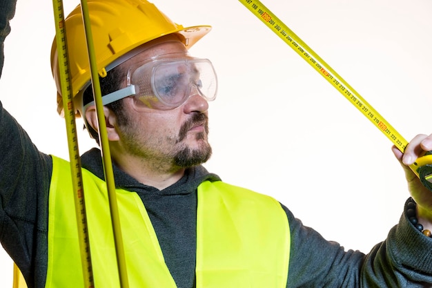 ein Mann, der eine Arbeit ohne Wissen machen will, eine Arbeit ohne Erfahrung. Machen Sie es sich selbst, Mann in gelbem Bauhelm mit Schutzbrille, der bereit ist, mit den Bauarbeiten zu beginnen