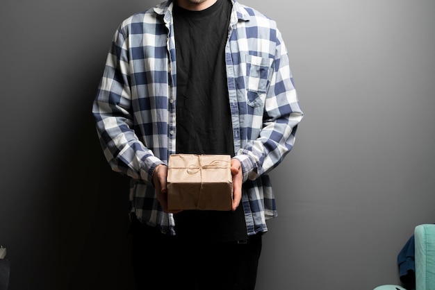 Ein Mann, der eine Geschenkbox als Geschenk für Feiertage in einer Papierverpackung hält