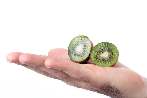 Ein Mann, der eine halbierte Kiwi in seiner Handfläche auf weißem Hintergrund hält