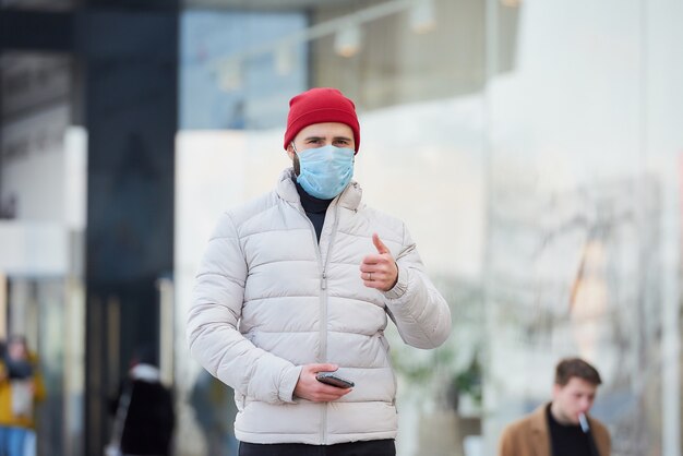 Ein mann, der eine medizinische gesichtsmaske trägt, um das verbreitete coronavirus (covid-19) zu vermeiden.