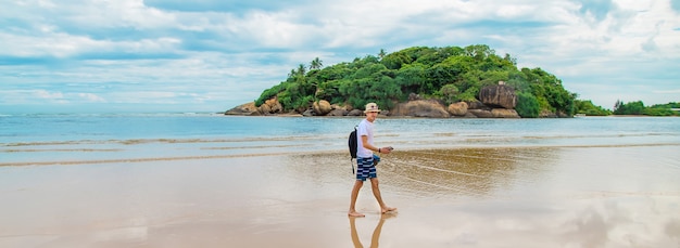 Ein Mann, der entlang des Strandes von Sri Lanka geht