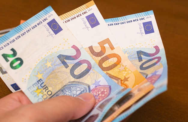 ein Mann, der Euro-Banknoten in der Hand hält