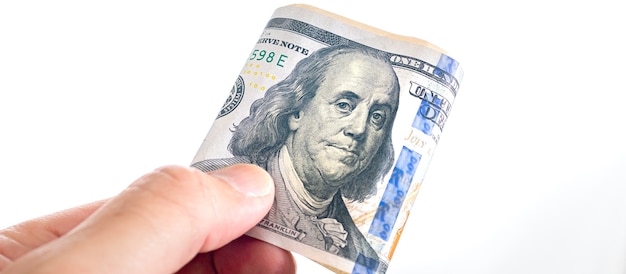 ein Mann, der gefaltete US-Dollar-Scheine auf weißem Hintergrund hält