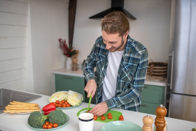 Ein Mann, der Gemüse schneidet, um einen Salat zu machen