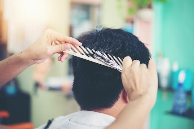 Ein mann, der haar am friseur schneidet