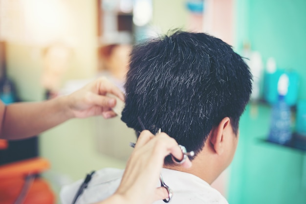 Ein Mann, der Haar am Friseur schneidet